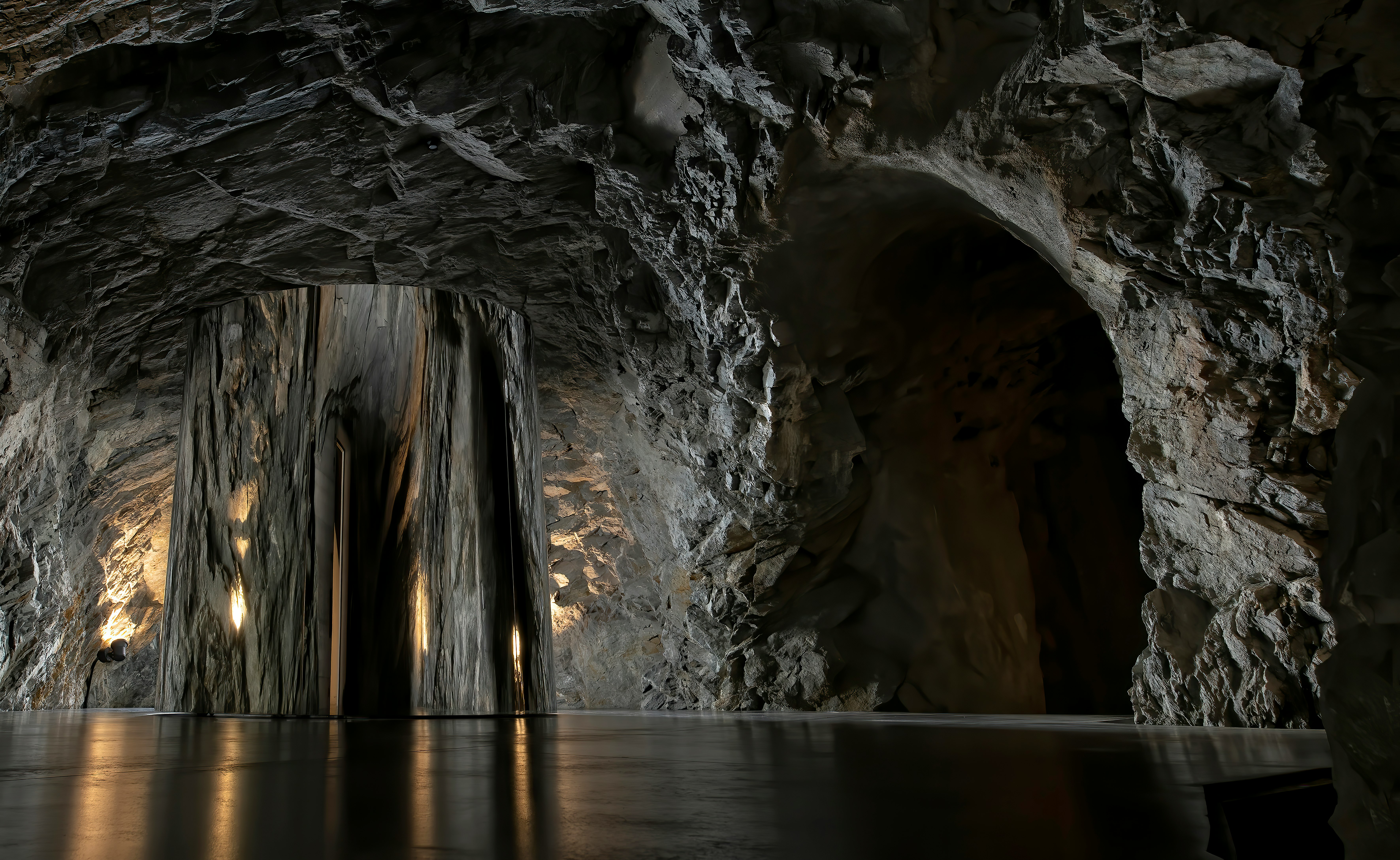 gray and black cave near body of water